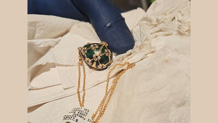 Police recovered this Fabergé pendant after a New Zealand man allegedly swallowed it in an Auckland jewelry store. (Photo courtesy of New Zealand police) Fabergé egg pendant near gloved hand