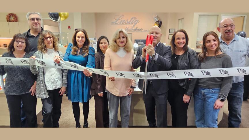 Michael Helfer, seen here holding the scissors at a reopening ceremony, is the new owner of Lustig Jewelers. (Image courtesy of Lustig Jewelers’ Facebook page) Lustig Jewelers employees in store