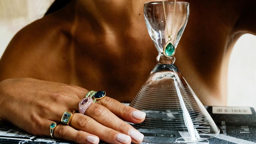 In the “One of One” collection are, from left to right, a “Button” pinky ring with tourmaline, signet ring with aquamarine, marquise-cut pink sapphire ring, “Spiral” ring with tourmaline and tsavorite, and a necklace with a deep green cabochon tourmaline that are all set in 14-karat yellow gold. (Image credit: Kat Irlin) Eriness One of One Collection Rings and Necklace