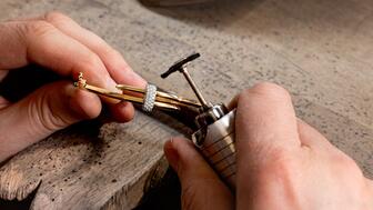 Ecksand, a Montreal-based jewelry brand, is planning its move to the U.S. market. Bench jeweler holding a bracelet and a tool