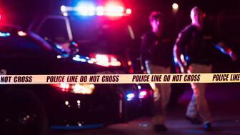 Stock image of crime scene with police cars and crime scene tape
