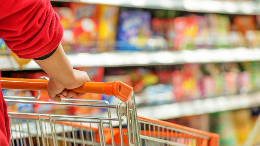 Hands pushing shopping cart