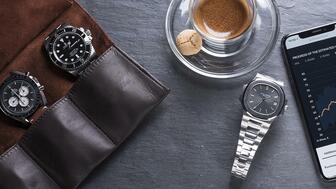 Online watch marketplace Chrono24 tracked which watch models have risen in value the most since 2018, and a few surprises are at the top of the list. Watches on a table next to a coffee cup