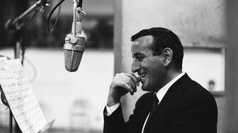 Black and white photo of Tony Bennett near a microphone
