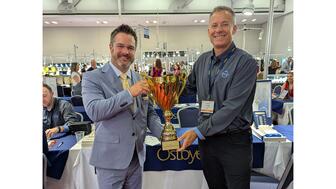 Ostbye President Craig MacBean, left, with Independent Jewelers Organization owner Stephen Barnes at the 2026 IJO show, held July 26 to 28 in Louisville, Kentucky. Ostbye was named IJO’s 2026 Vendor of the Year at the show. Ostbye receiving Vendor of the Year trophy at 2026 IJO show