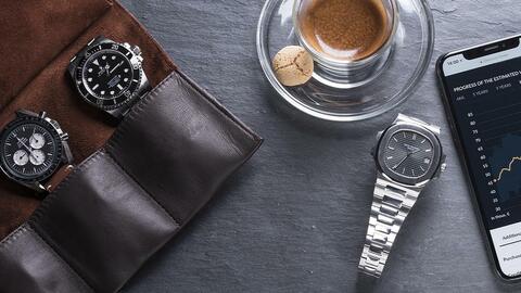 Watches on a table next to a coffee cup